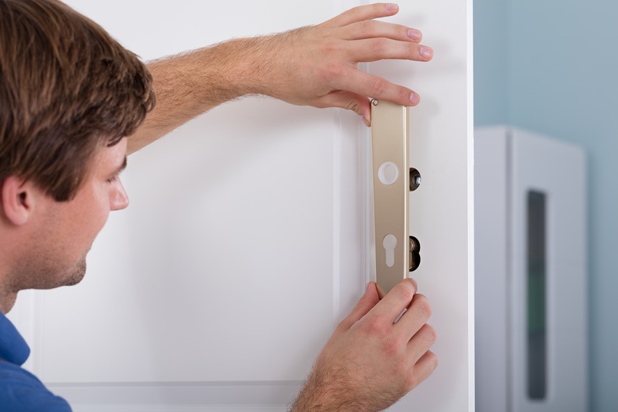 Technician performing lock maintenance for a commercial clien